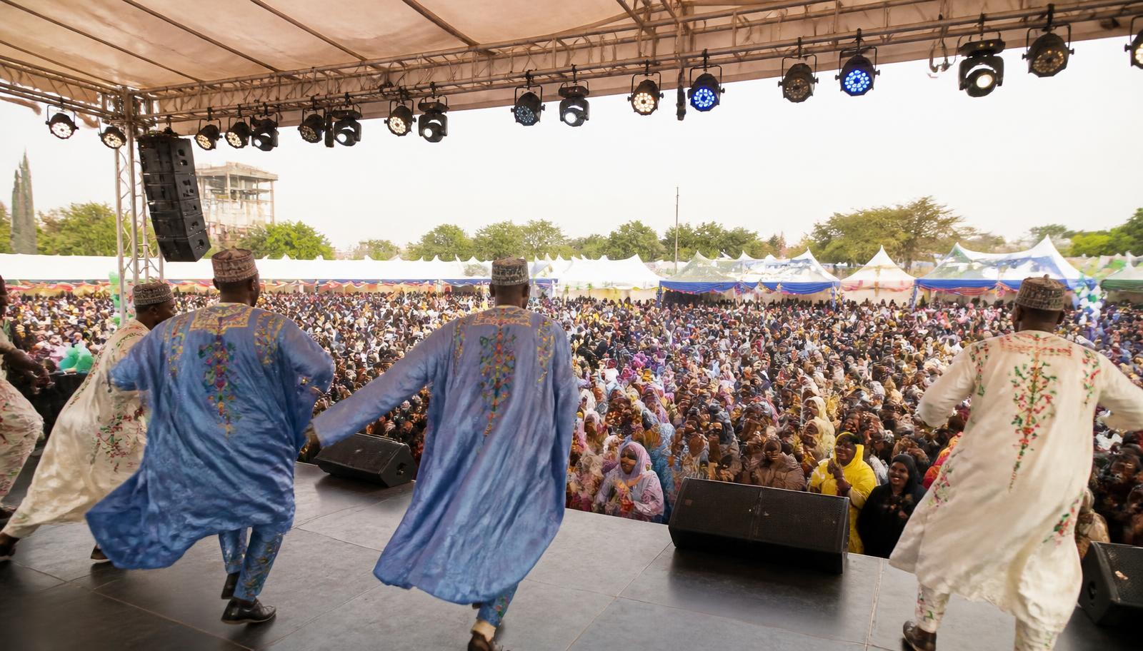 Northern Nigerian dance troupe performing to a large crowd